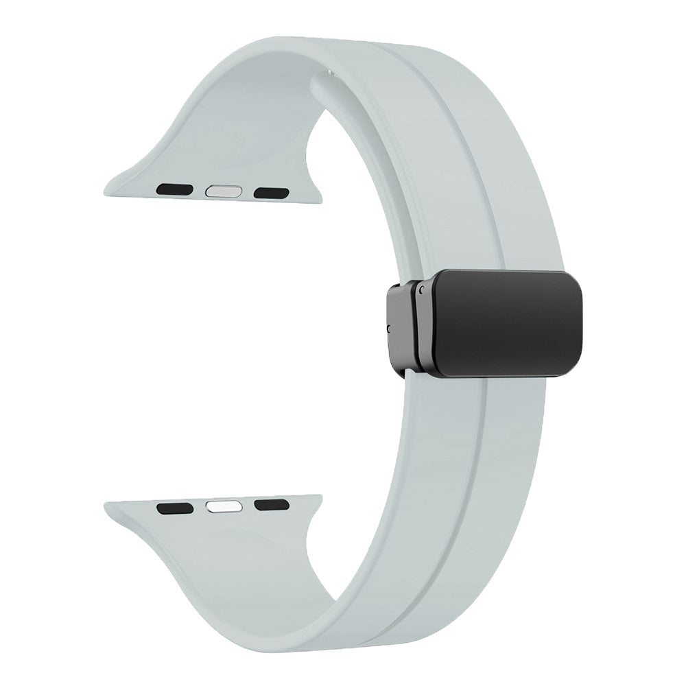 White silicone smartwatch band with black magnetic deployant clasp and connector pins for Apple Watch