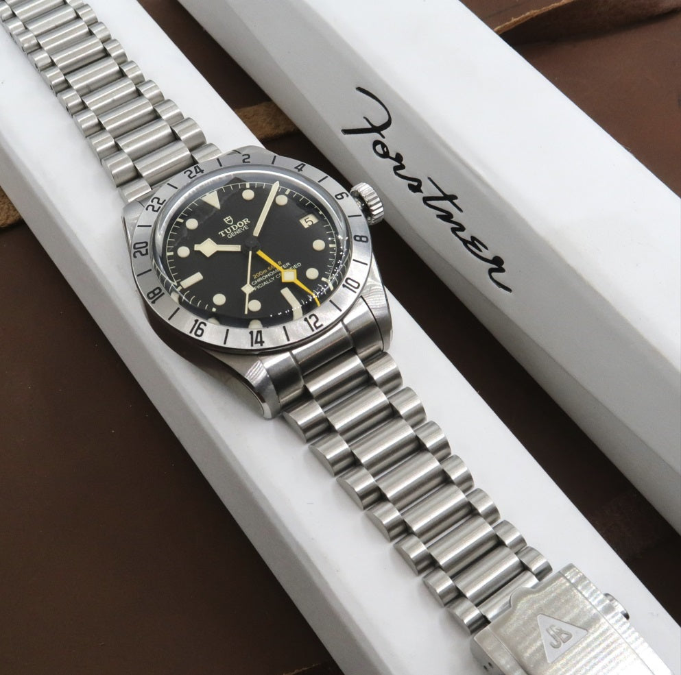 Tudor Black Bay Pro stainless steel dive watch with GMT bezel and matching metal bracelet on display box