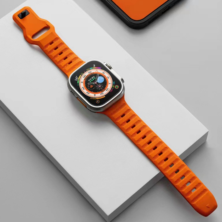 Orange ridged sports rubber Apple Watch band with matching smartwatch on white display block