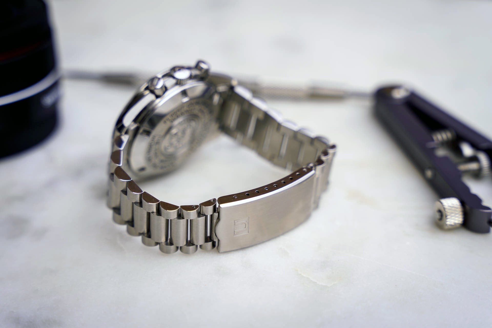 Stainless steel bracelet for Omega Speedmaster 20mm with solid link construction and integrated end links displayed on white surface