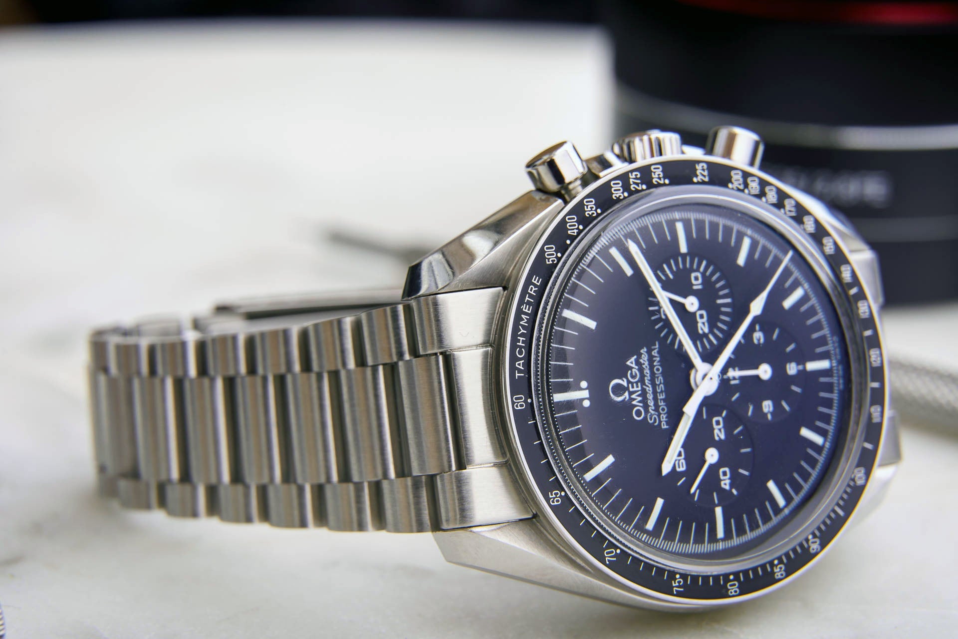 Omega Speedmaster professional chronograph watch with stainless steel bracelet and black dial featuring tachymeter bezel