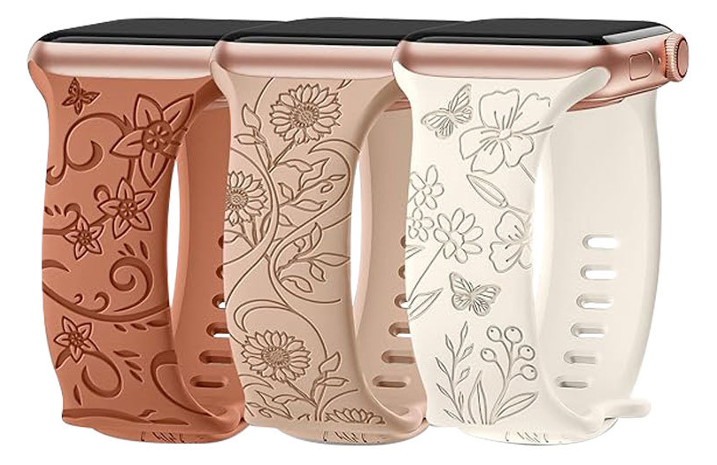 Three Apple Watch silicone bands in floral designs, rose gold, tan, and cream colors with embossed flower patterns