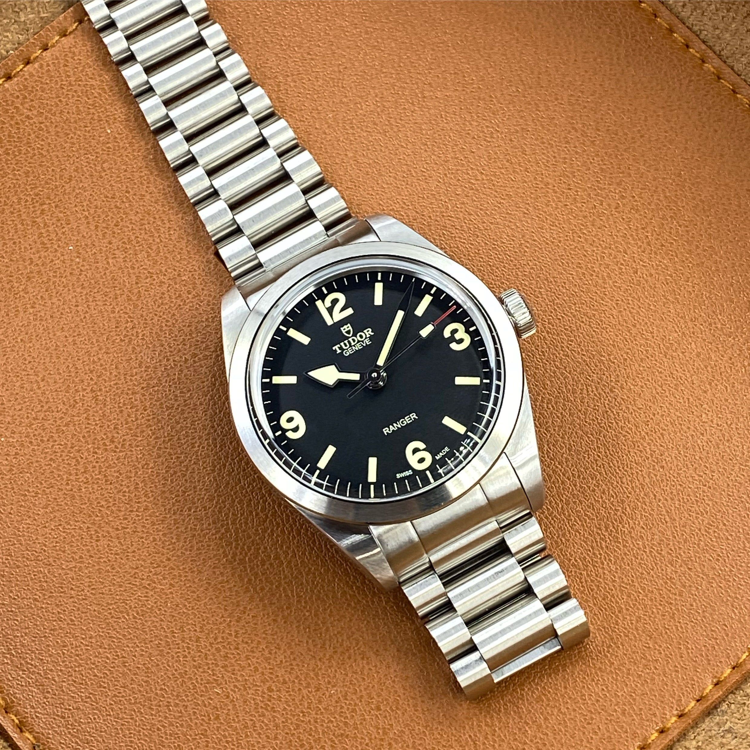 Tudor Ranger 39 watch with stainless steel bracelet on tan leather background