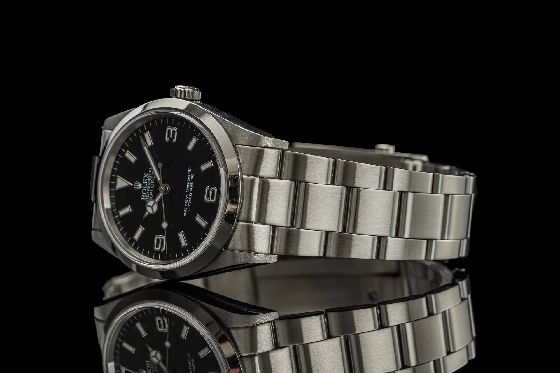 Rolex Explorer 114270 stainless steel watch with black dial and matching bracelet on reflective black surface