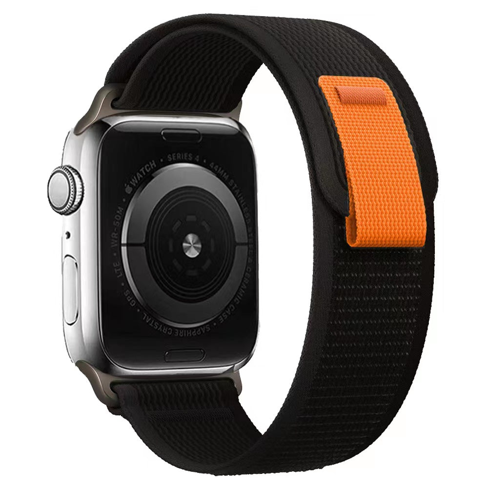 Silver Apple Watch Series 4 with black and orange Trail Loop band featuring woven nylon design
