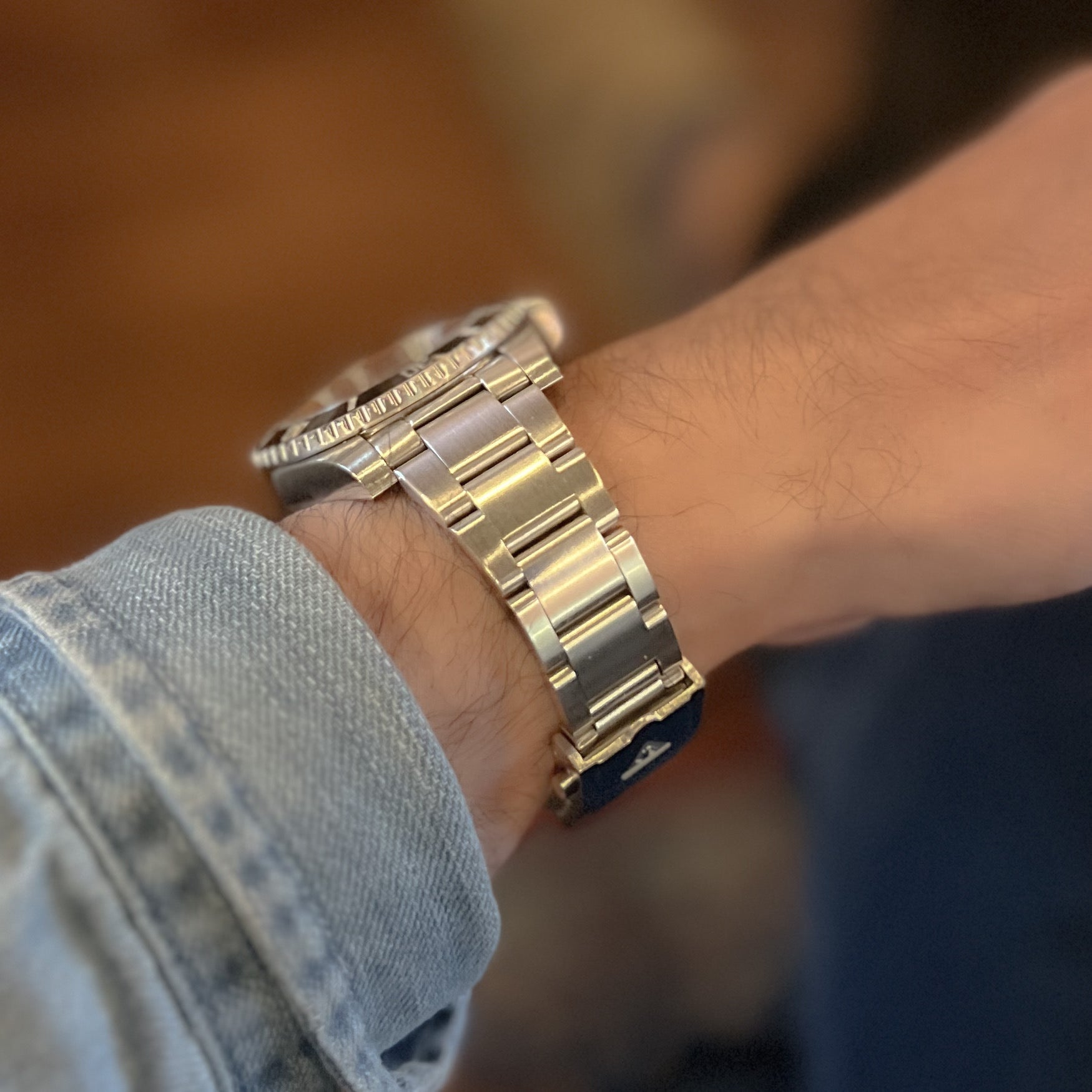 Two-tone stainless steel and gold bracelet watch band on wrist with solid link construction for Rolex professional models