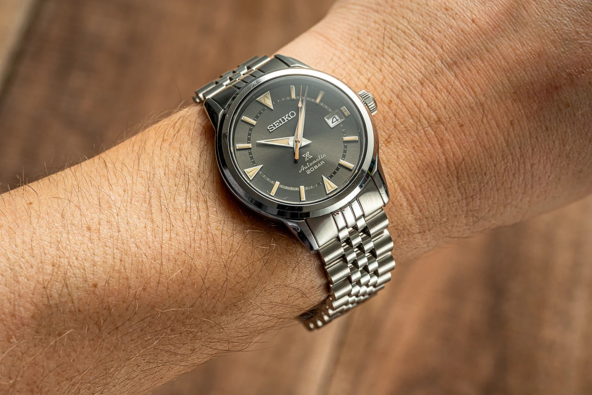 Seiko Alpinist automatic watch with black dial and steel bracelet on wrist