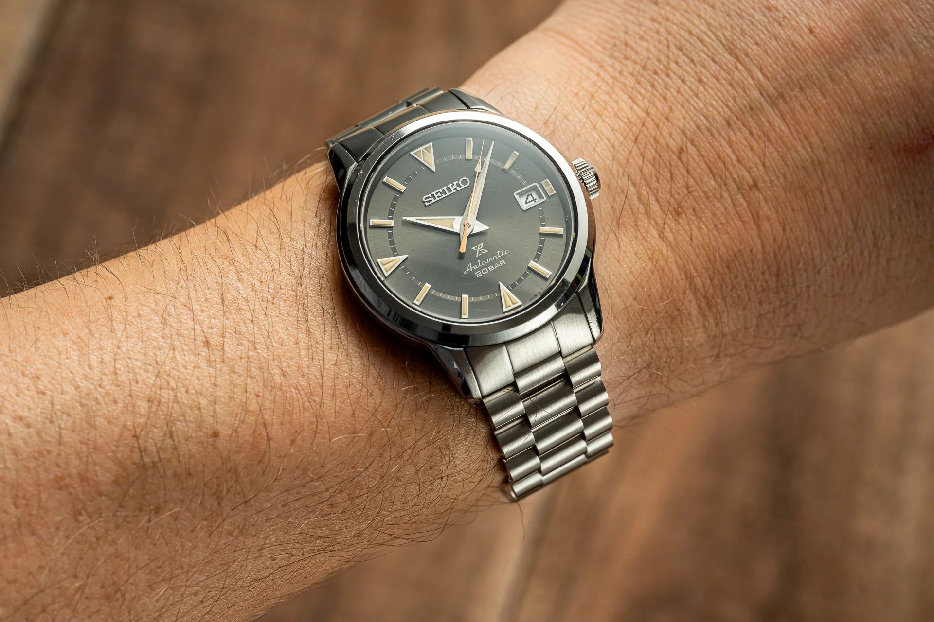 Seiko Alpinist automatic watch with dark dial and stainless steel bracelet worn on wrist