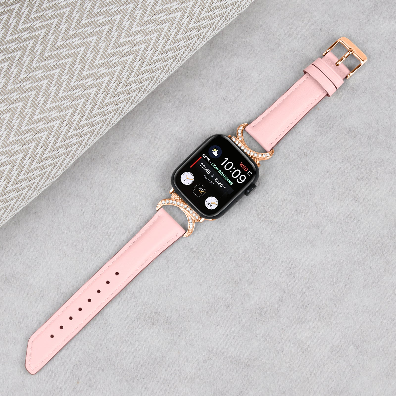 Pink leather smartwatch band with rose gold rhinestone-studded connectors and buckle for Apple Watch