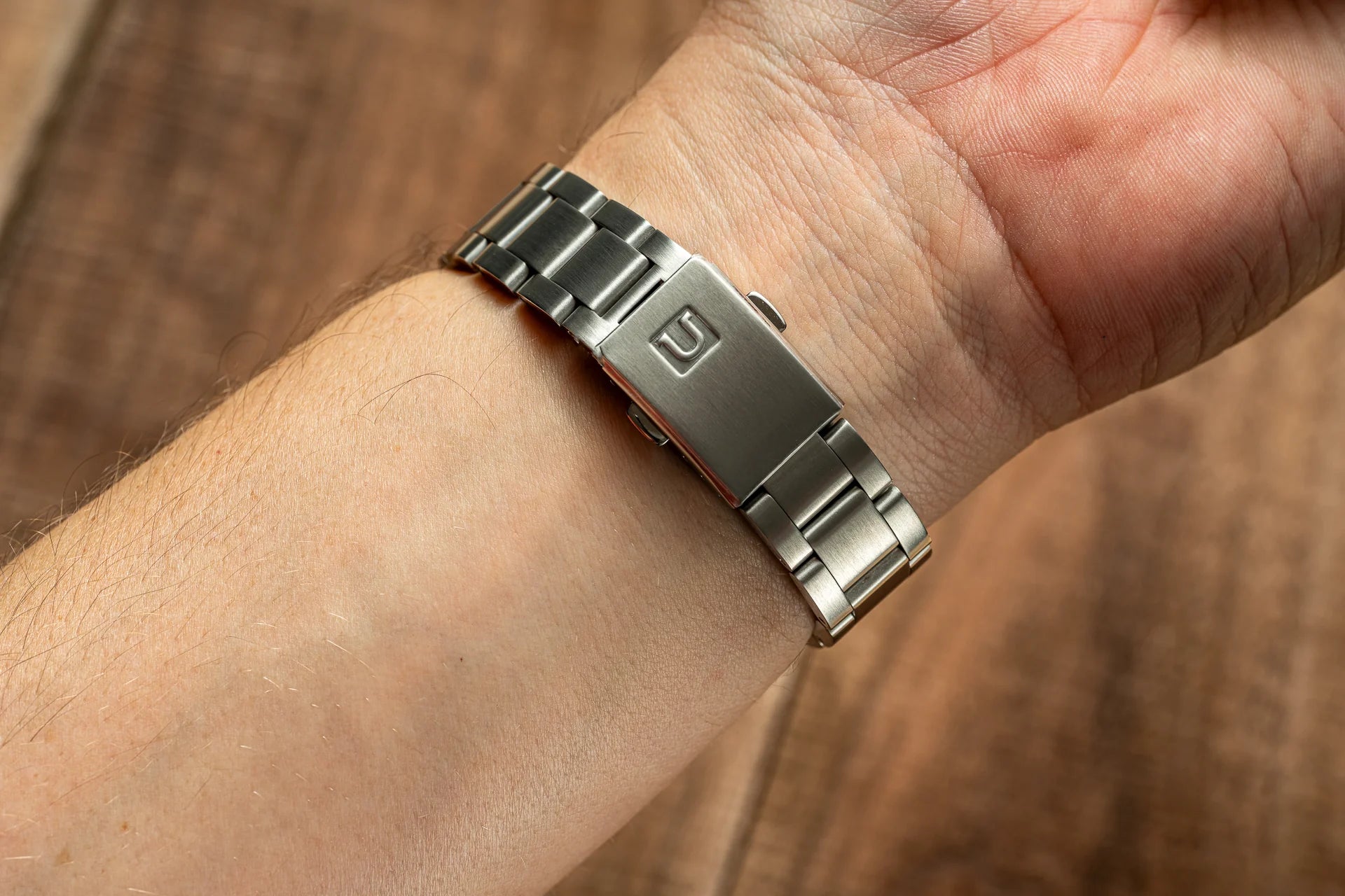 Stainless steel link bracelet with red accent band worn on man's wrist, compatible with Seiko 19mm Alpinist watch