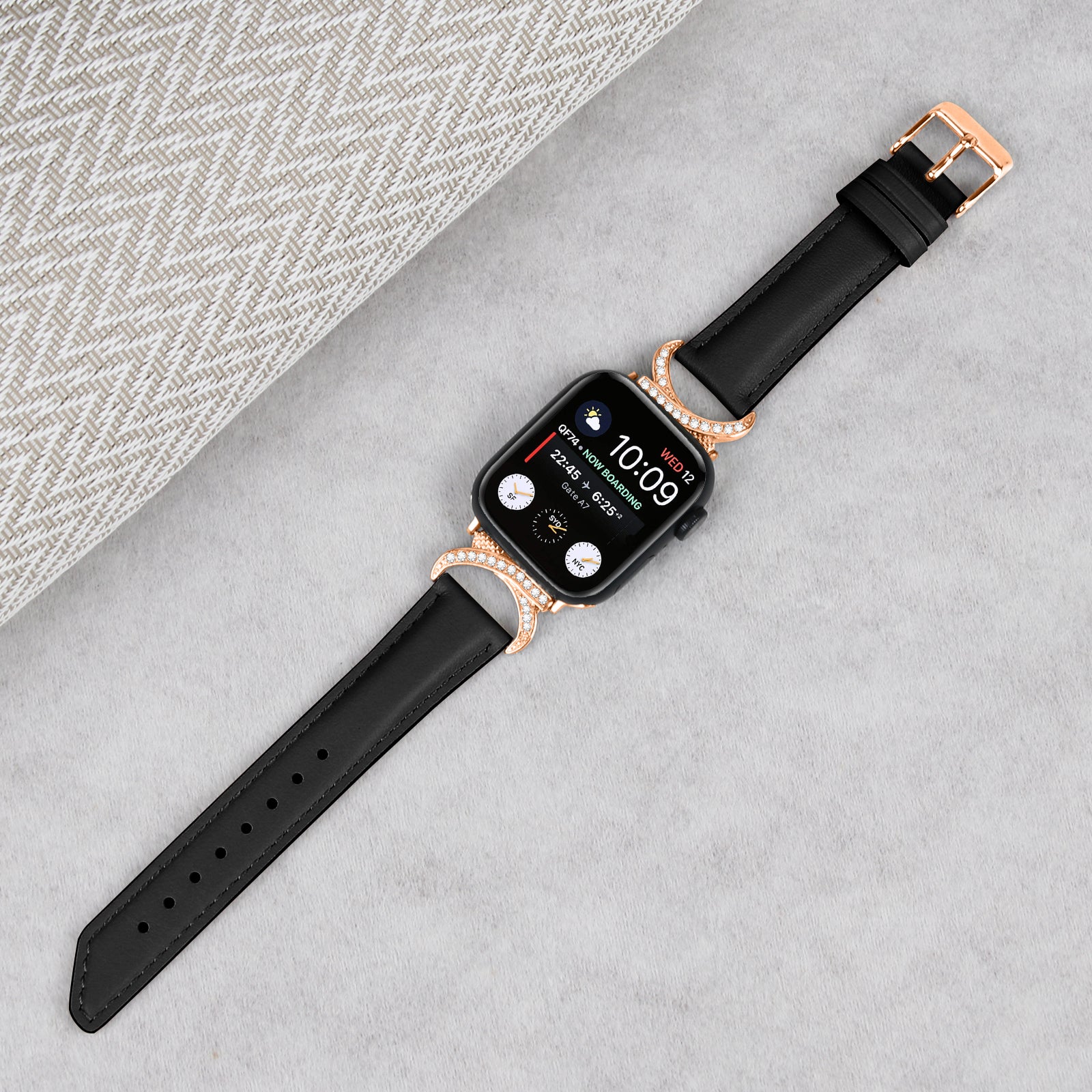 Black leather smartwatch band with rose gold crystal-studded connector and buckle for Apple Watch