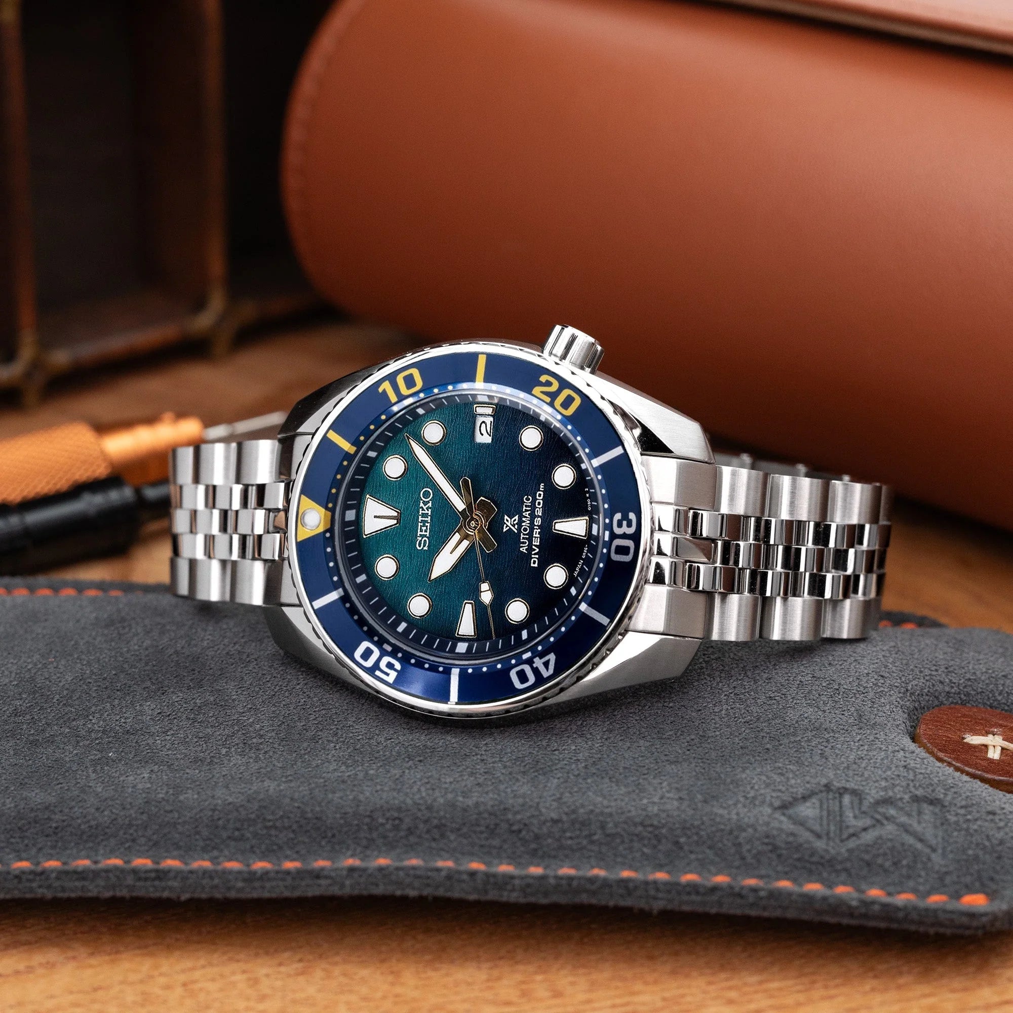 Seiko Sumo dive watch with stainless steel Angus-J Louis bracelet, blue dial, and rotating bezel on leather watch roll