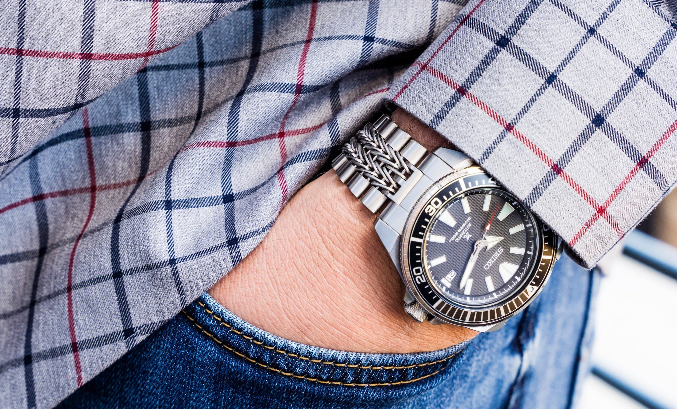 Seiko Samurai dive watch with stainless steel bracelet worn on wrist with plaid shirt and jeans