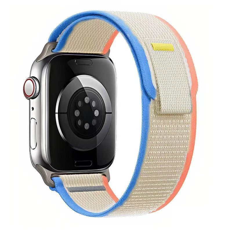Silver Apple Watch with colorful trail loop band in blue, cream and coral nylon weave material