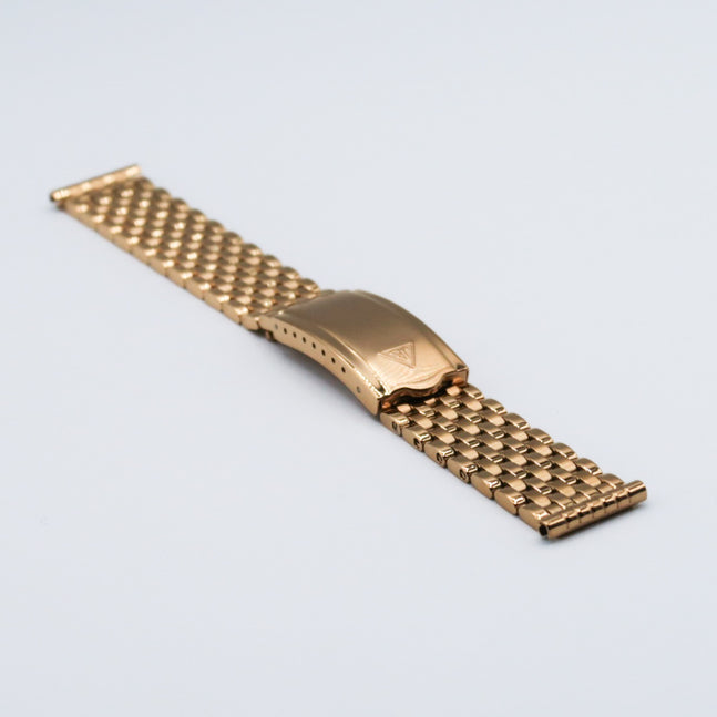 Gold plated seven-row beads of rice watch bracelet with matching clasp on white background