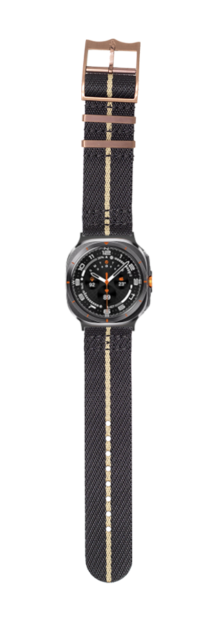 Black fabric watch strap with bronze hardware and black dial sport watch featuring orange accents and tan canvas detail