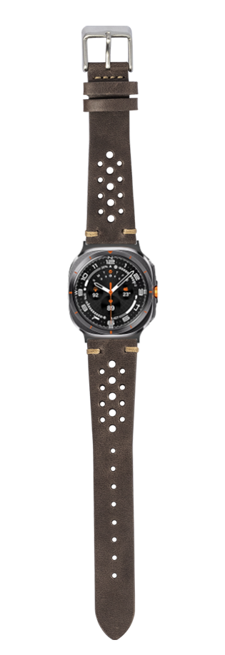 Dark brown vintage rally leather watch strap with perforated design, silver buckle, and orange accents on sport watch face