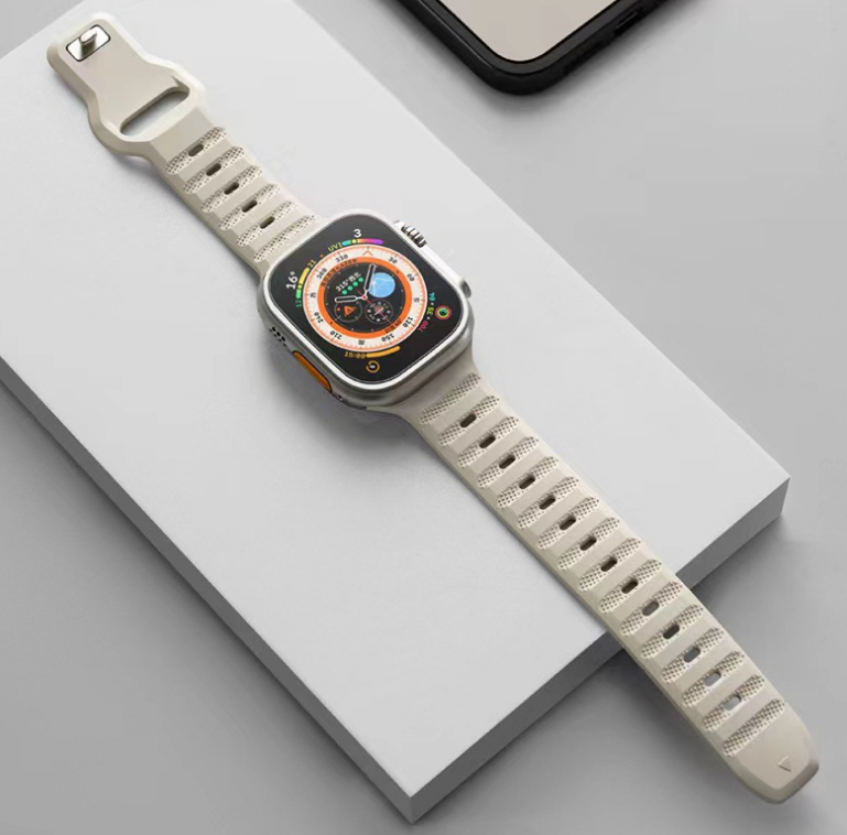 Smartwatch with square stainless steel case, orange and blue digital dial, cream ridged silicone sport band on white platform