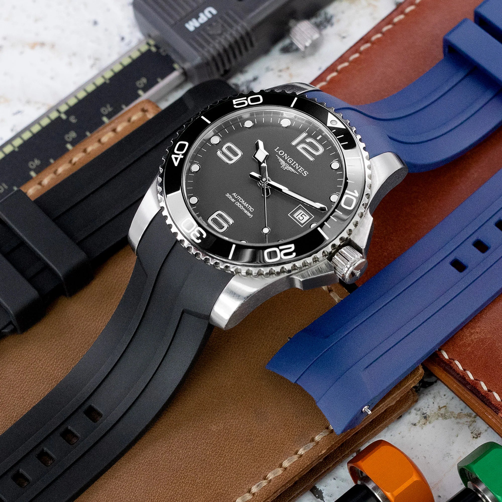 Longines Hydroconquest 41mm watch with black dial and stainless steel case displayed on black FKM rubber quick-release curved strap alongside leather and blue strap alternatives
