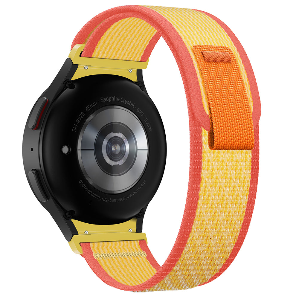 Black smartwatch with sapphire crystal display and red-yellow woven trail loop band with gold hardware connectors