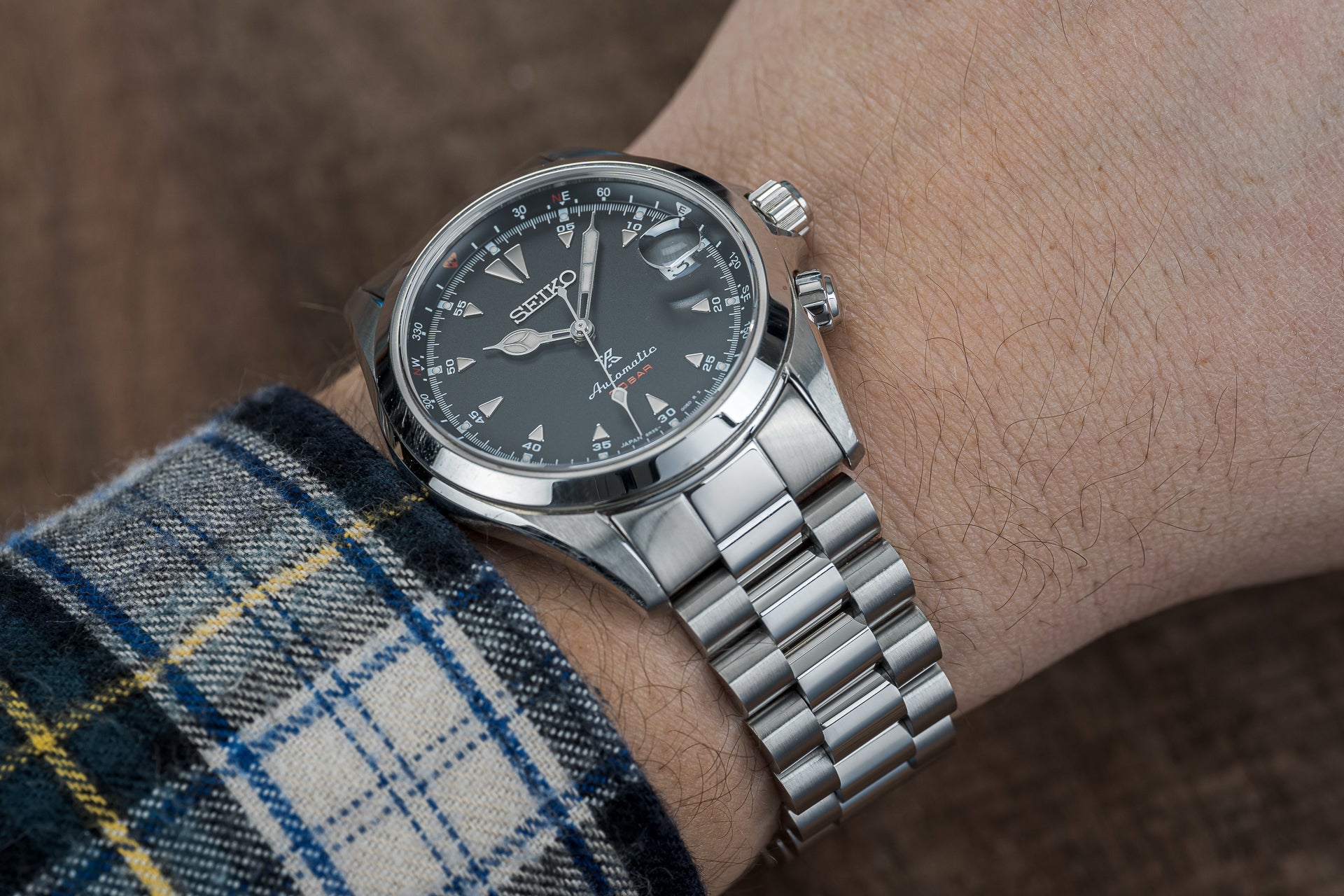 Seiko Sarb017 automatic watch with black dial and stainless steel bracelet worn on wrist with plaid shirt cuff