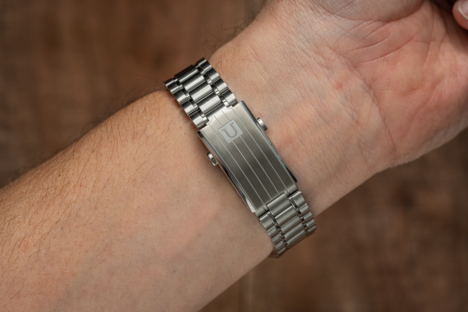 Stainless steel Omega Aqua Terra 41mm watch bracelet worn on wrist, showing polished metal links and adjustable band detail