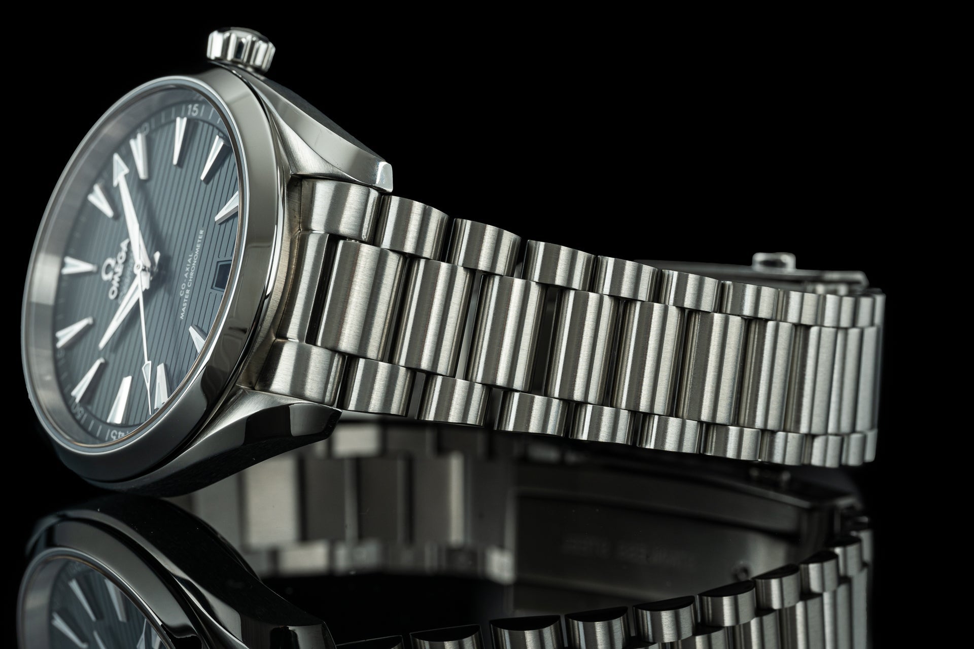 Stainless steel bracelet watch with charcoal dial and metal link band on black background