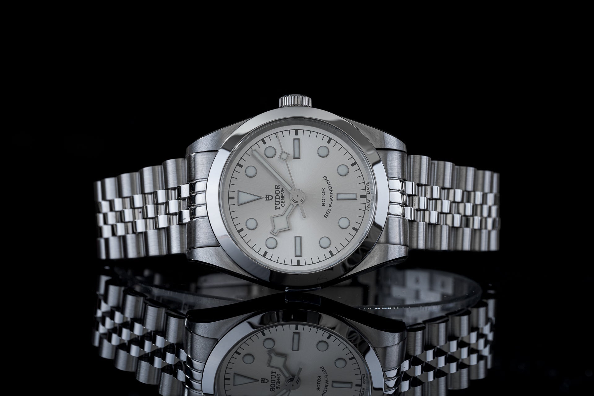 Stainless steel Tudor Black Bay 36 watch with silver dial and matching bracelet on black background