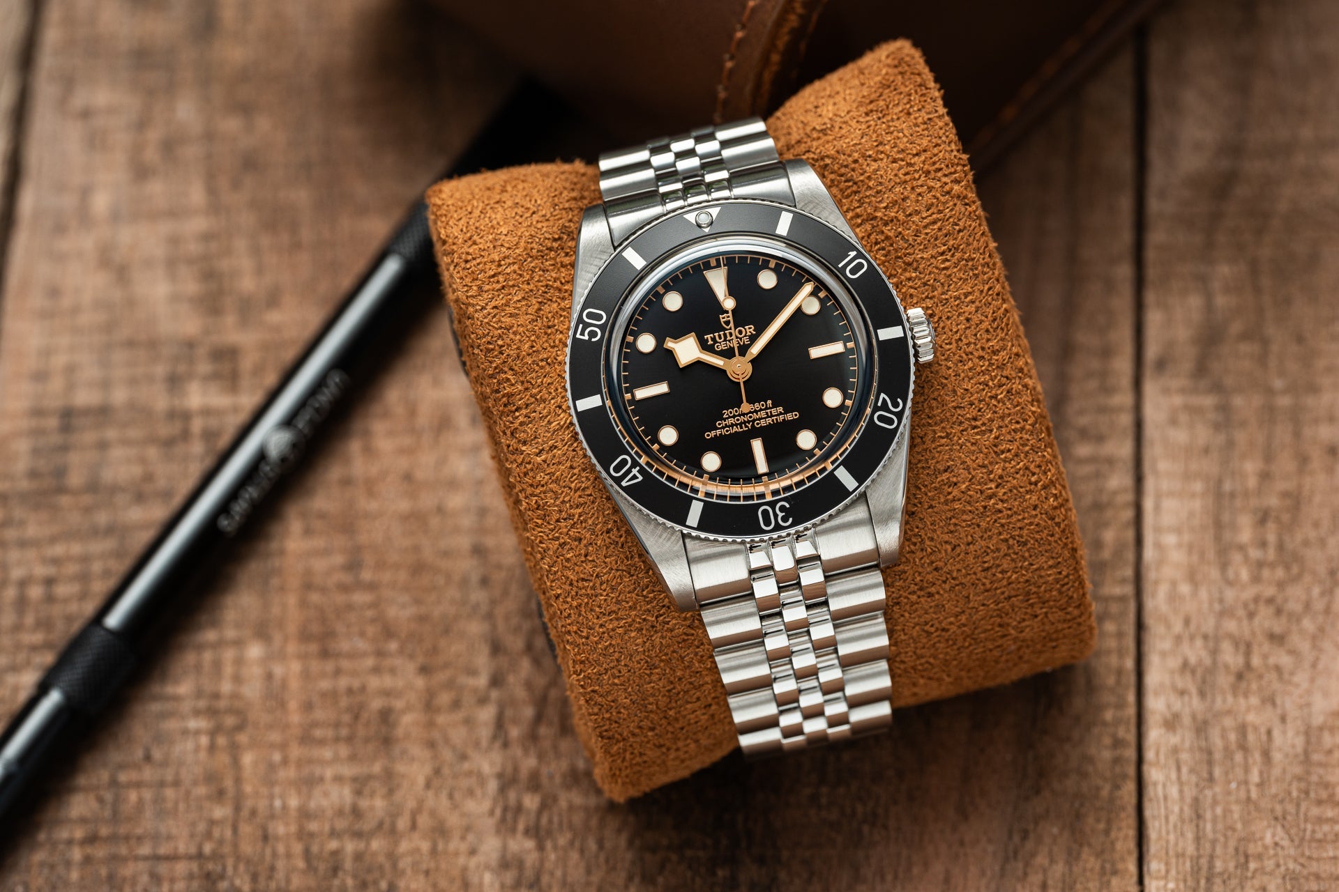 Tudor Black Bay 54 dive watch with stainless steel bracelet on brown suede display pad, vintage-inspired chronometer-certified timepiece
