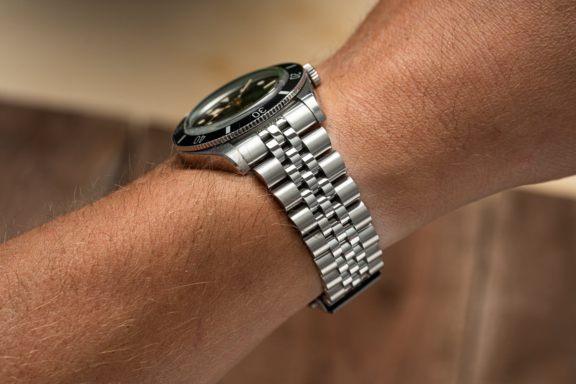 Stainless steel executive bracelet with jubilee links worn on wrist with Tudor Black Bay 54 dive watch