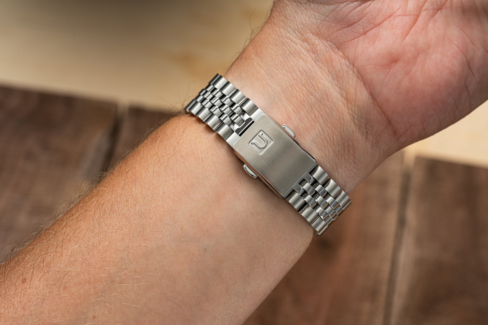 Stainless steel bracelet with solid link design worn on wrist, featuring brushed center link and polished outer links, compatible with Tudor Black Bay 54