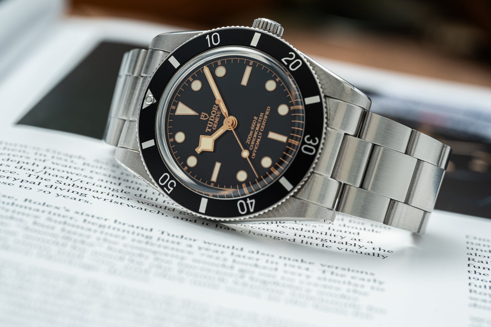 Tudor Black Bay 54 stainless steel dive watch with black dial, rose gold hands, and rotating bezel on bracelet