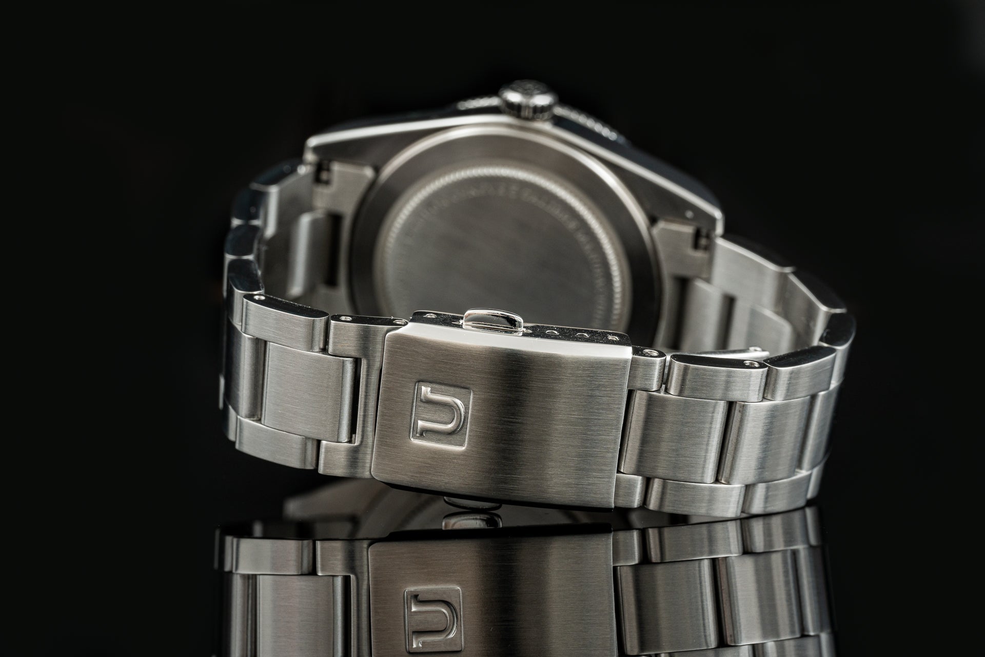 Stainless steel bracelet with deployant clasp for Tudor Black Bay 54 watch on black background