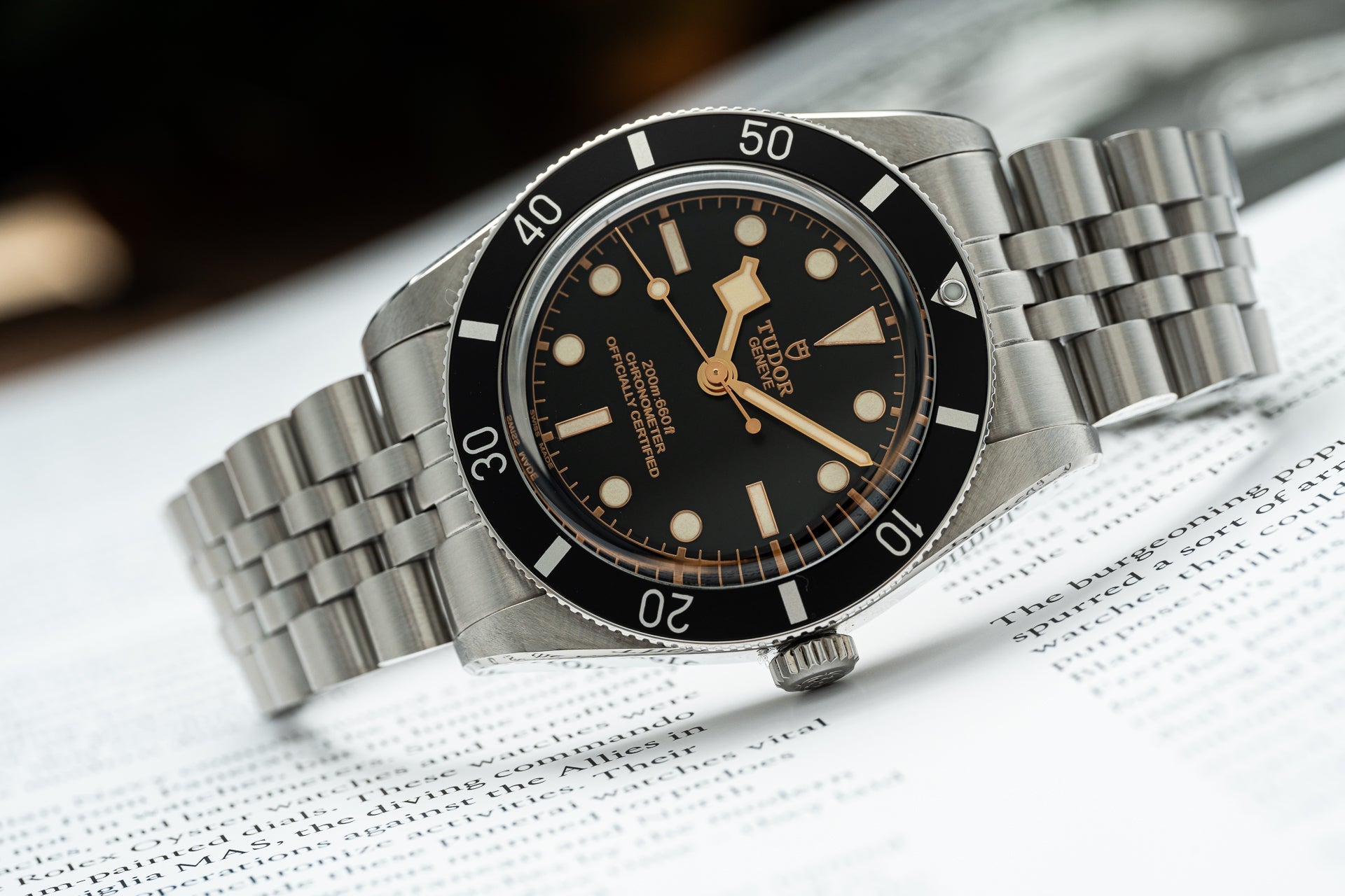 Stainless steel Tudor Black Bay 54 dive watch with black dial, rose gold hands, and rotating bezel on jubilee bracelet