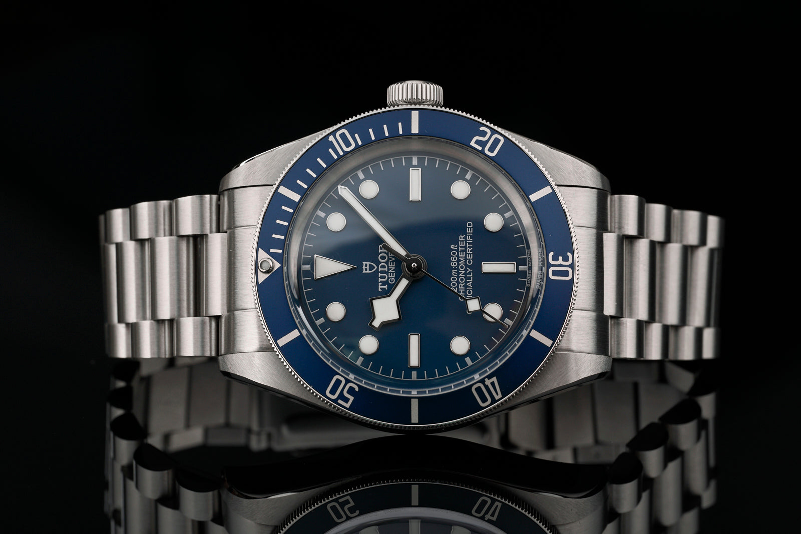 Tudor Black Bay 58 dive watch with blue dial, stainless steel bracelet, and rotating bezel on black background
