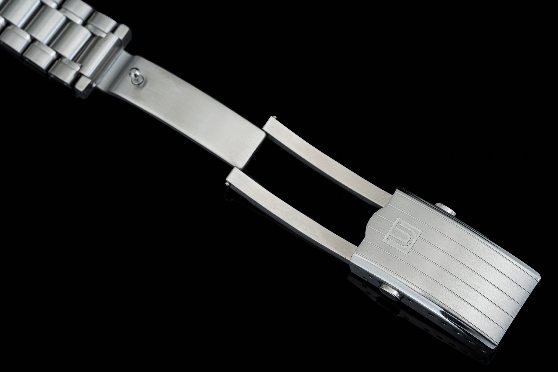 Stainless steel bracelet for Tudor Black Bay 58 with solid links and integrated end links against black background