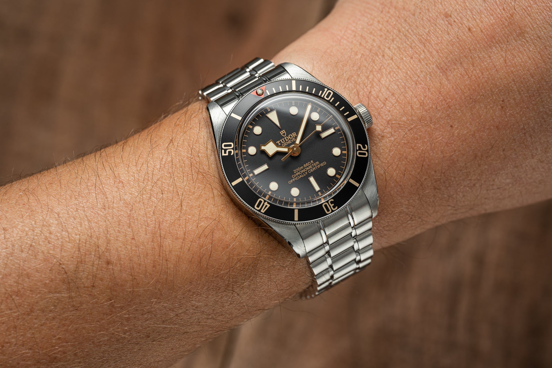 Tudor Black Bay 58 dive watch with stainless steel bracelet on wrist, black dial with gilt indices and 200m water resistance