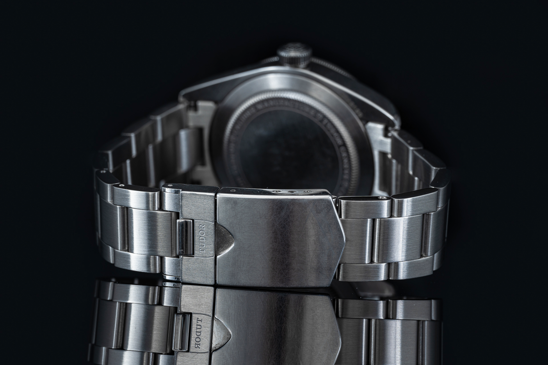 Stainless steel bracelet for Tudor Black Bay 58 watch with polished links and secure fold-over clasp on black background