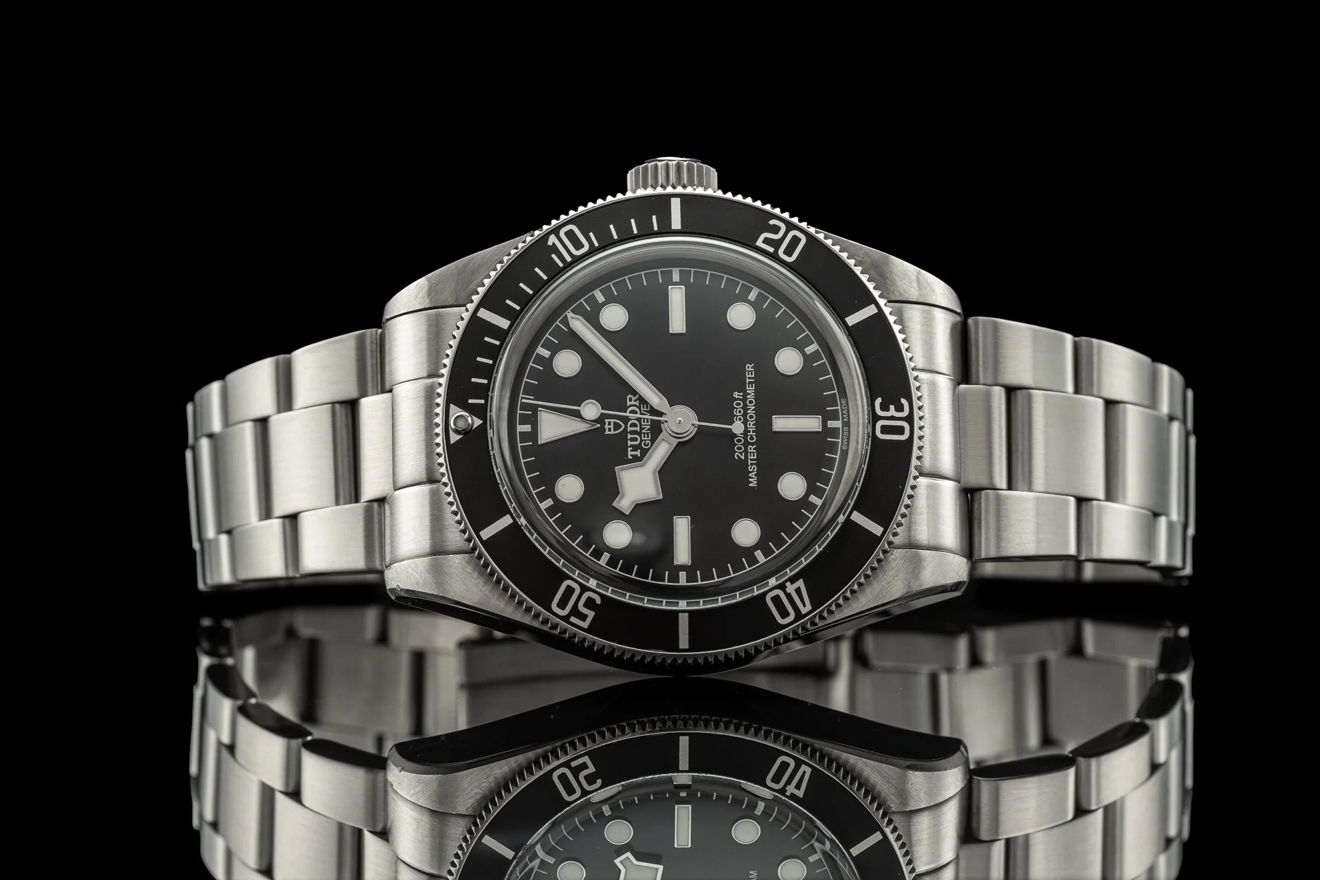 Stainless steel dive watch with black dial, rotating bezel, and matching metal bracelet on black background