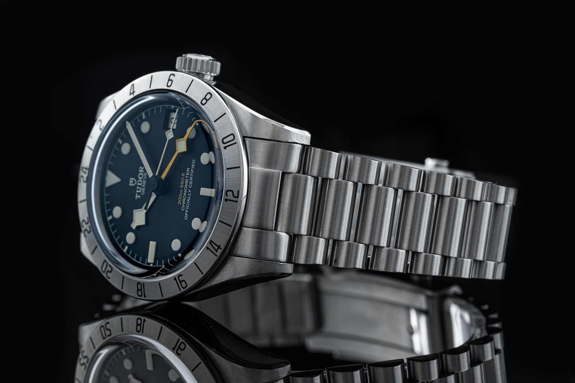 Tudor Black Bay Pro stainless steel diving watch with rotatable bezel and matching metal bracelet on black background