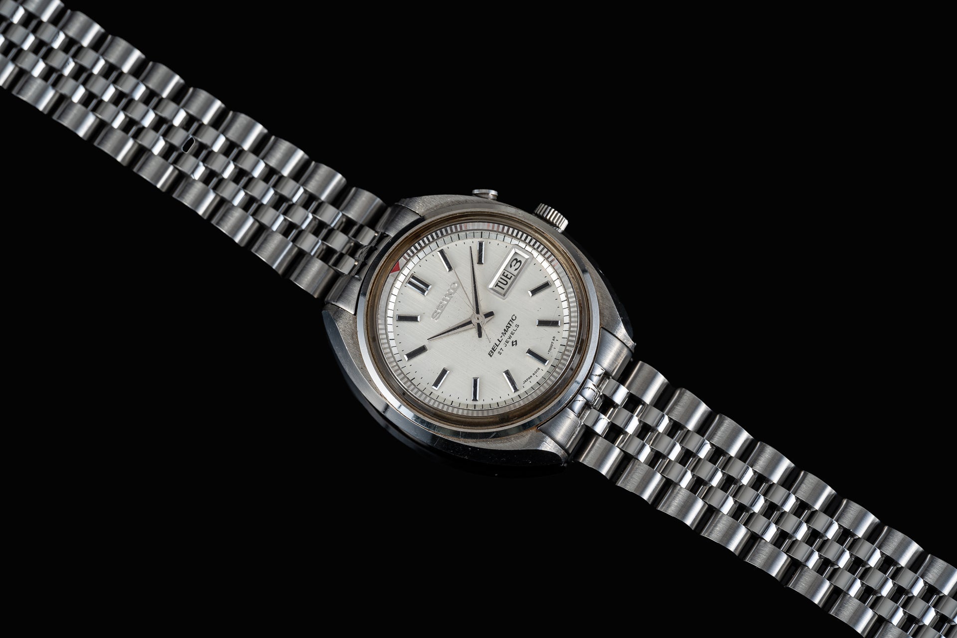 Vintage Seiko Bell-Matic stainless steel automatic watch with cream dial, day-date window, and matching metal bracelet on black background