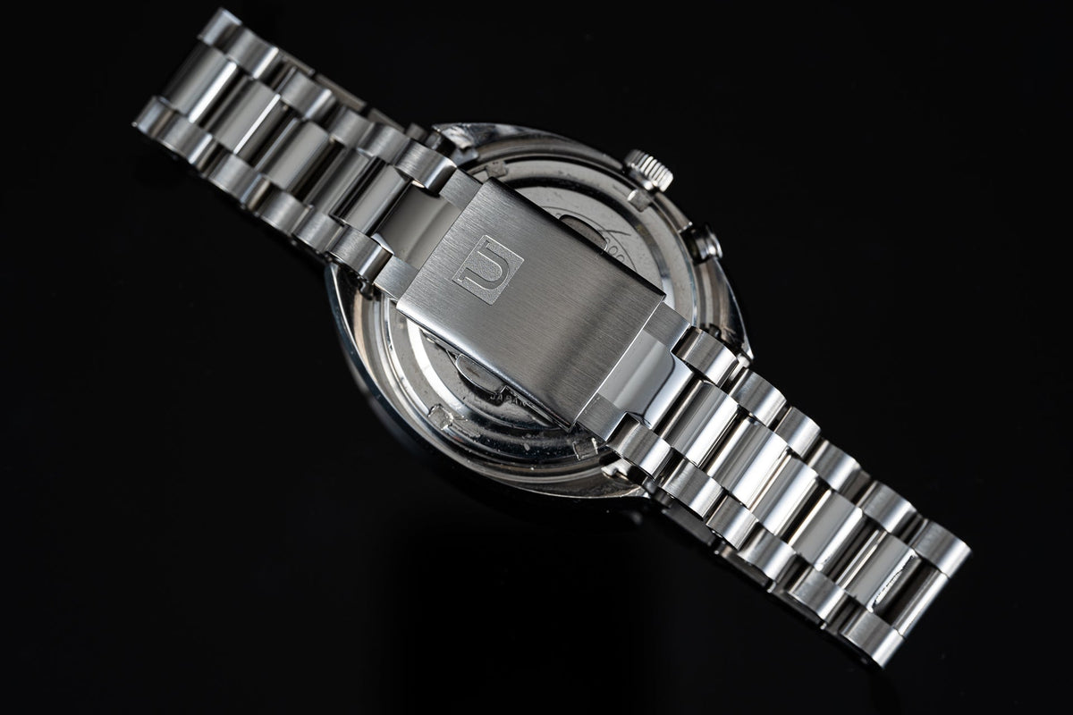 Silver stainless steel automatic watch with metal bracelet and cushion case displayed against black background