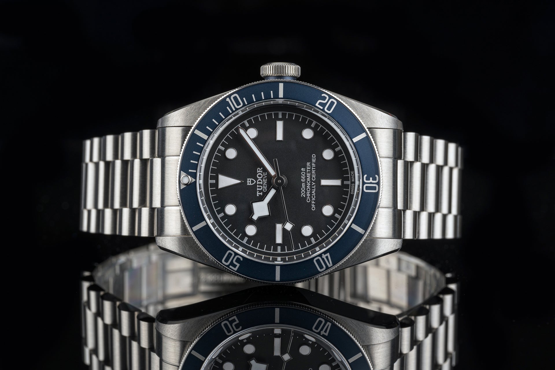 Stainless steel dive watch with black dial, blue bezel, luminous hands and hour markers on metal bracelet