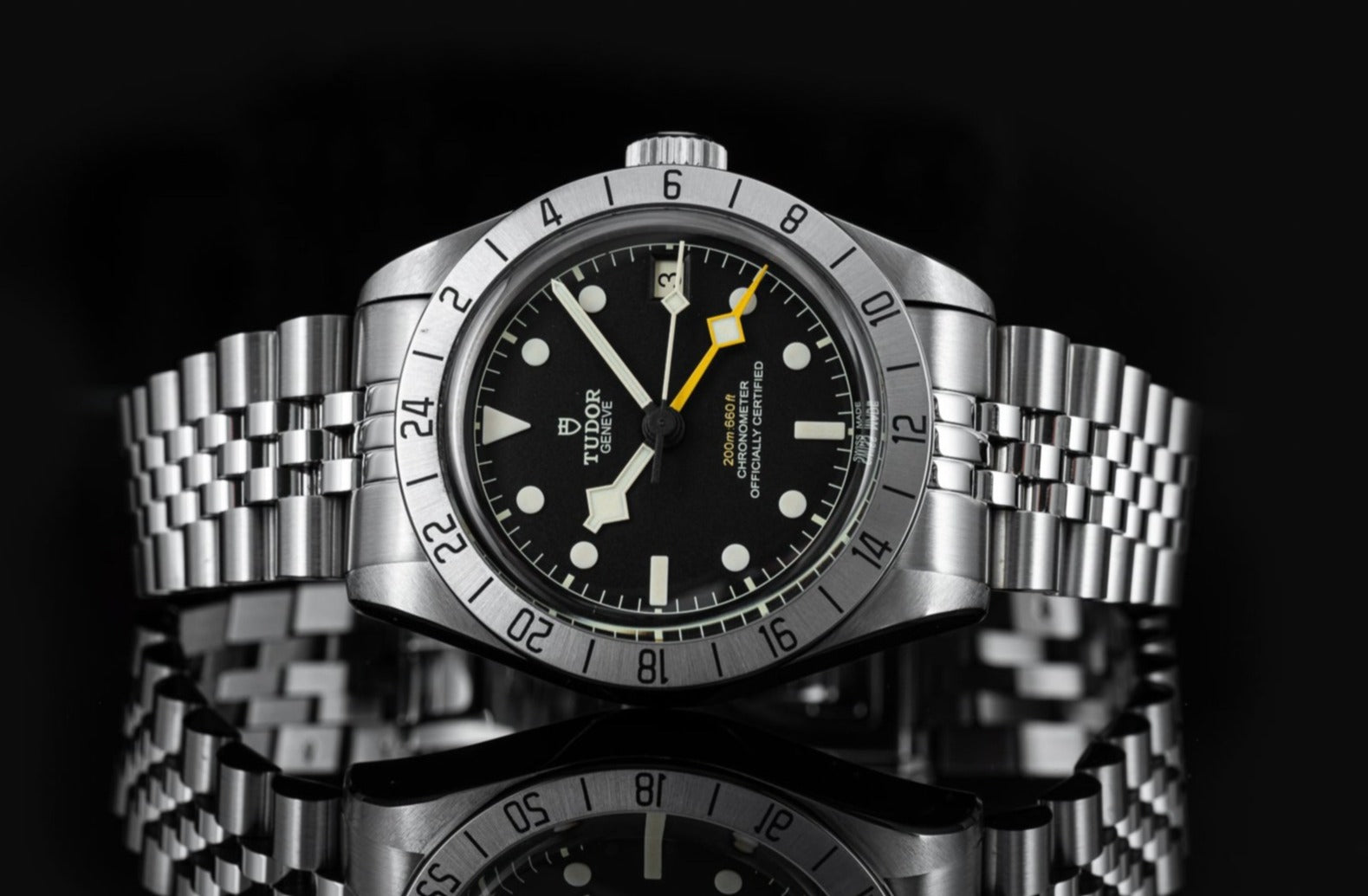Tudor Black Bay Pro stainless steel dive watch with black dial, luminous hour markers, yellow GMT hand, and rotating bezel bracelet