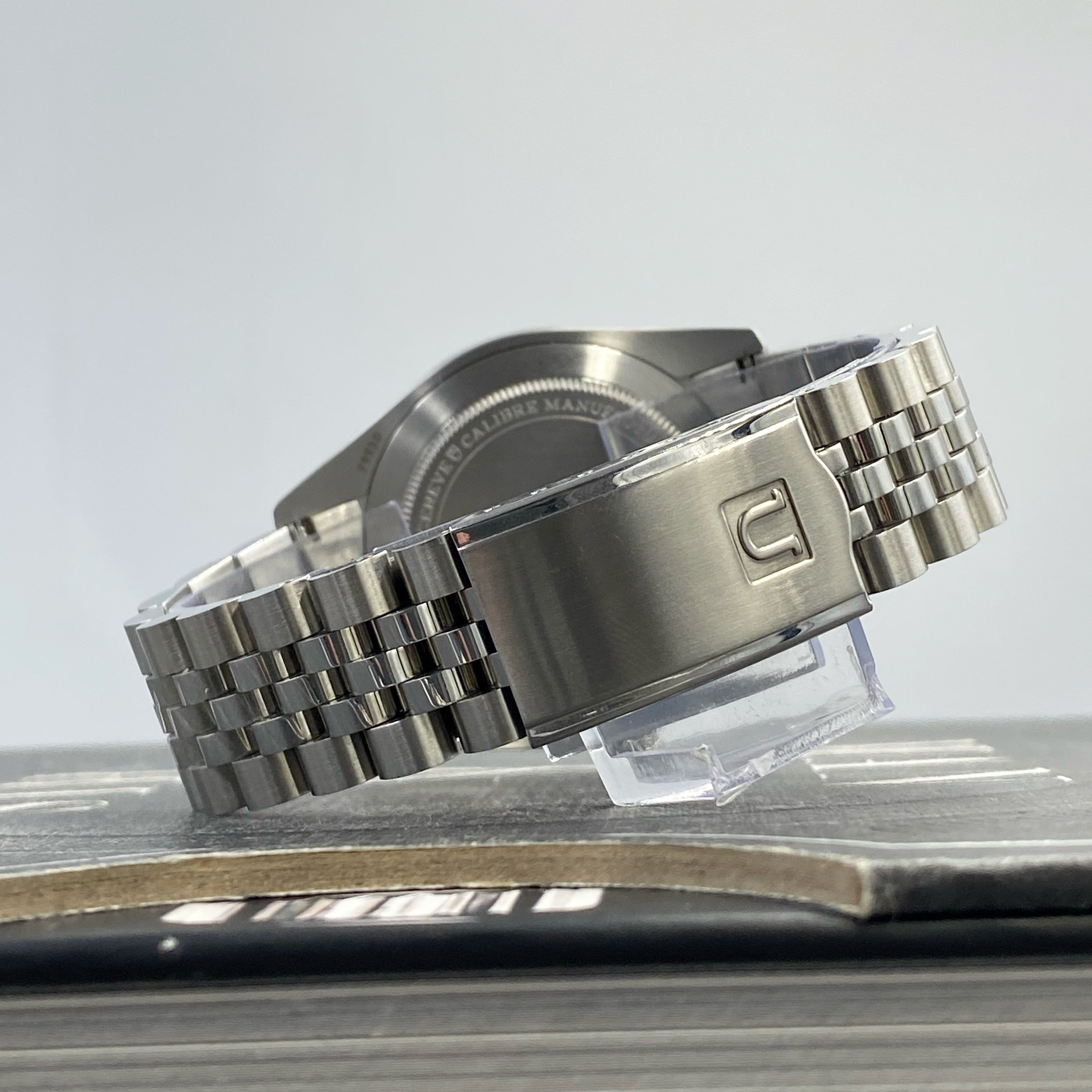 Stainless steel executive bracelet with fold-over clasp for Tudor Ranger 39 watch displayed on stand