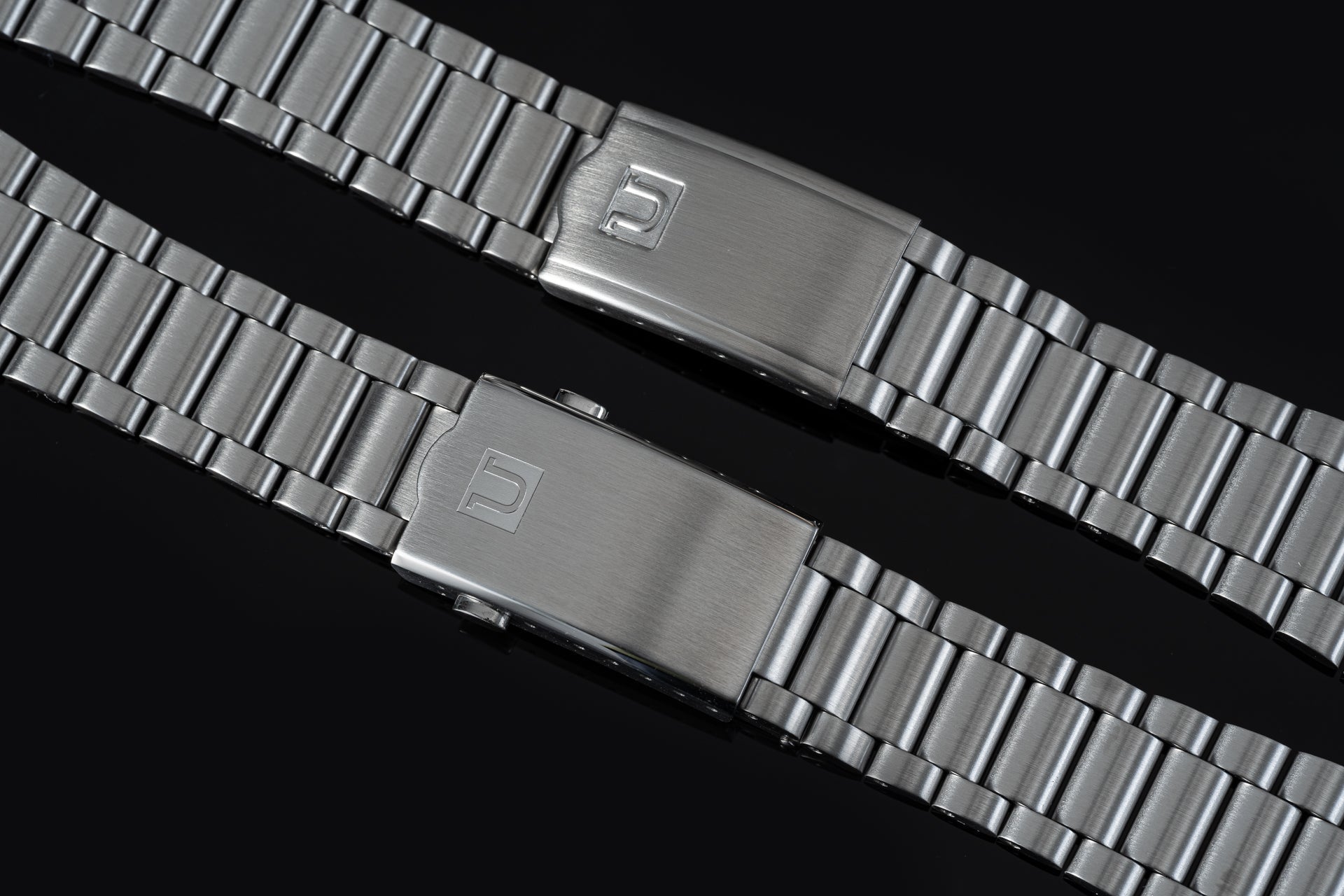 Stainless steel watch bracelets with brushed finish and branded clasp, compatible with Omega Speedmaster Mark II timepieces