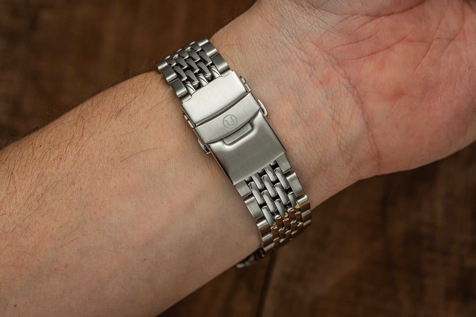 Stainless steel beads of rice watch bracelet on wrist with push-button deployment clasp and brushed finishing