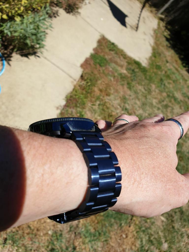 Stealth Night Blue stainless steel link band on wrist showing clasp closure and polished finish detail