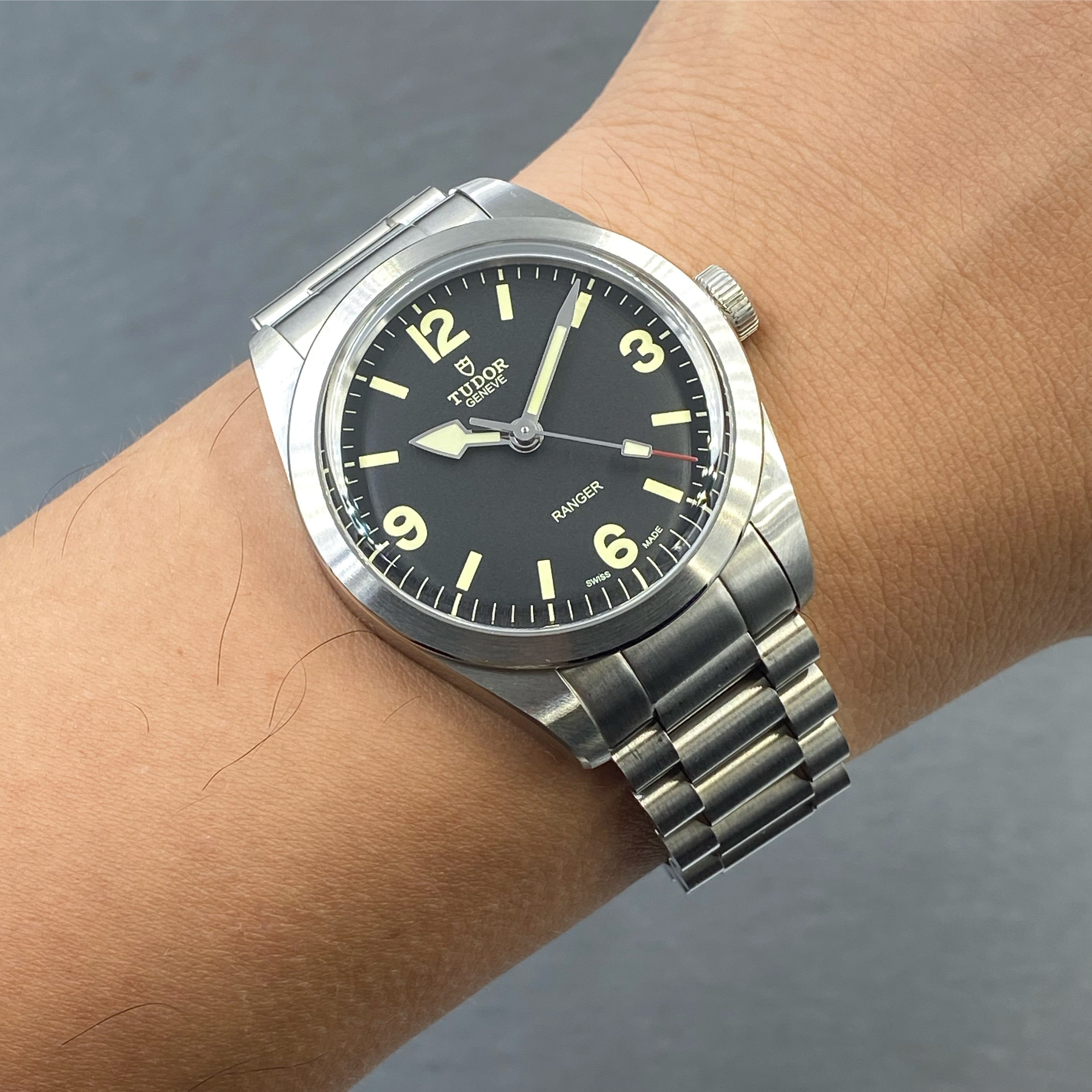 Tudor Ranger 39 stainless steel watch with black dial and luminous hour markers on bracelet worn on wrist