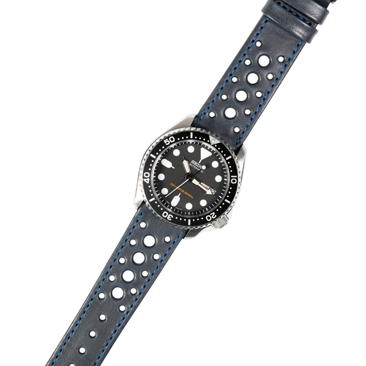Black dial dive watch with stainless steel case and navy blue perforated leather quick release strap with blue stitching